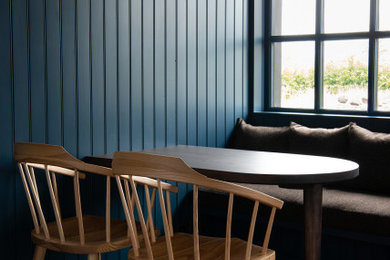Modelo de comedor de estilo americano pequeño con con oficina, paredes azules, suelo de madera oscura, suelo marrón y machihembrado
