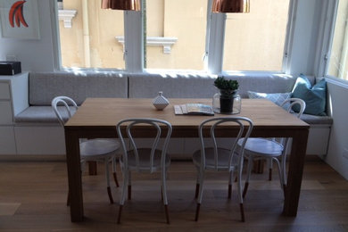 Cette photo montre une petite salle à manger ouverte sur la cuisine tendance avec un mur beige et parquet clair.