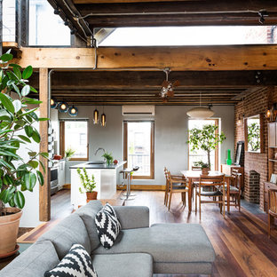 Inspiration for an industrial medium tone wood floor kitchen/dining room combo remodel in New York with a standard fireplace and a brick fireplace