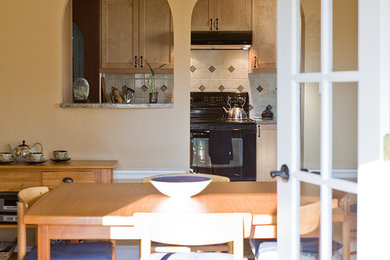 Foto de comedor de estilo americano de tamaño medio cerrado con paredes beige y suelo de madera en tonos medios