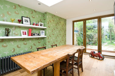 Ejemplo de comedor nórdico con paredes verdes, suelo de madera clara y suelo marrón