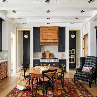 Large country dining room in Charlotte with light hardwood floors, white walls and a standard fireplace.