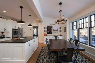 Example of a large country medium tone wood floor and brown floor kitchen/dining room combo design in Milwaukee with white walls and no fireplace