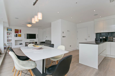 Offenes Modernes Esszimmer ohne Kamin mit weißer Wandfarbe und hellem Holzboden in London