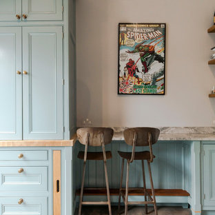 This is an example of a small traditional kitchen/dining room in London with grey walls, light hardwood flooring and brown floors.