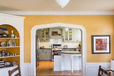 Imagen de comedor campestre grande cerrado sin chimenea con paredes amarillas, suelo de madera en tonos medios y suelo marrón