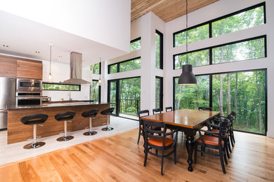 Huge trendy light wood floor dining room photo in Montreal with white walls