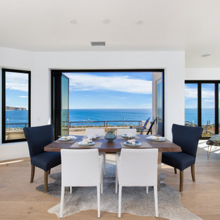 Example of a huge beach style medium tone wood floor, brown floor, wood ceiling and wood wall great room design in Orange County with white walls, a corner fireplace and a tile fireplace