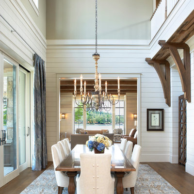 Example of a beach style medium tone wood floor and brown floor dining room design in Other with white walls