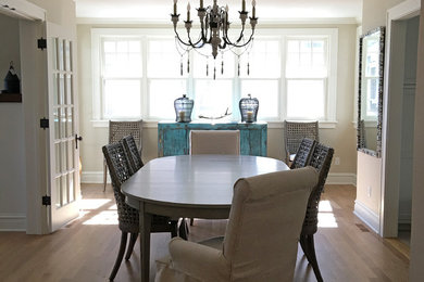 Inspiration for a mid-sized coastal light wood floor and brown floor enclosed dining room remodel in Other with beige walls and no fireplace