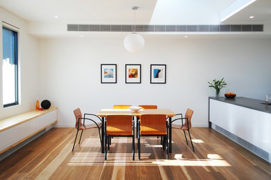 Imagen de comedor de cocina contemporáneo pequeño sin chimenea con paredes blancas y suelo de madera en tonos medios