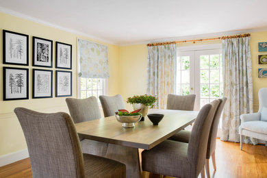 Inspiration for a mid-sized transitional medium tone wood floor and brown floor enclosed dining room remodel in Boston with yellow walls and no fireplace