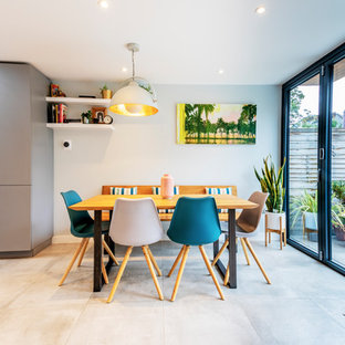 Photo of a scandi kitchen/dining room in London with white walls and beige floors.