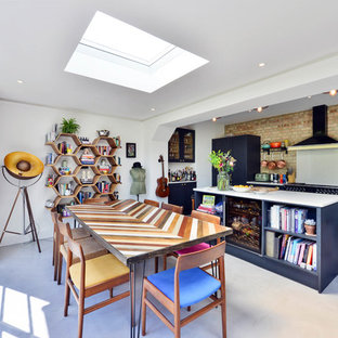 Idee per una grande sala da pranzo aperta verso la cucina eclettica con pareti bianche, pavimento in cemento e pavimento grigio