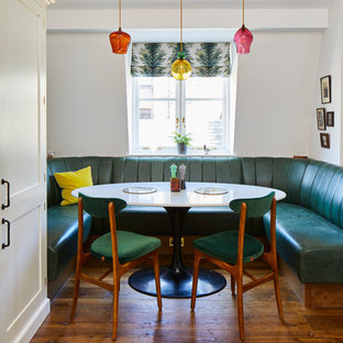 Inspiration for an eclectic dining room in London with white walls, medium hardwood flooring and brown floors.