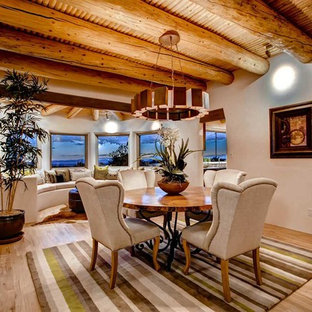 Imagen de comedor de estilo americano, abierto, con suelo de madera clara y paredes beige