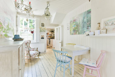 Inspiration for a small romantic enclosed dining room in Sussex with painted wood flooring, white floors and white walls.