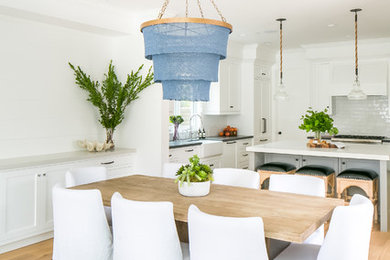 Example of a mid-sized beach style light wood floor kitchen/dining room combo design in Orange County with white walls
