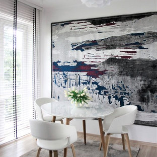 Immagine di una piccola sala da pranzo minimalista chiusa con pareti bianche, pavimento in laminato, nessun camino e pavimento arancione