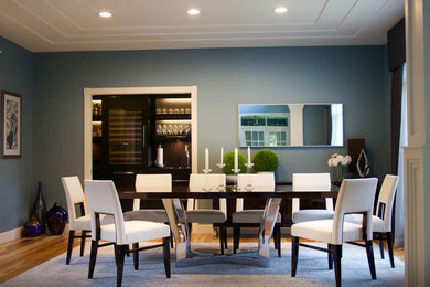 Example of a large transitional light wood floor enclosed dining room design in Detroit with blue walls and a standard fireplace