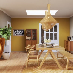 Idées déco pour une salle à manger éclectique fermée et de taille moyenne avec un mur beige, un sol en bois peint, cheminée suspendue, un manteau de cheminée en métal et un sol beige.