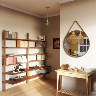 Inspiration pour une salle à manger bohème fermée et de taille moyenne avec un mur beige, un sol en bois peint, cheminée suspendue, un manteau de cheminée en métal et un sol beige.