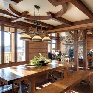 Modelo de comedor de estilo americano, grande, abierto, sin chimenea, con paredes marrones y suelo de madera en tonos medios