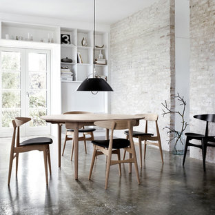 Immagine di una sala da pranzo industriale con pavimento in cemento