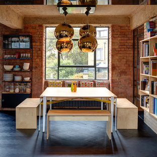 Immagine di una sala da pranzo industriale con pareti rosse, parquet scuro e pavimento nero