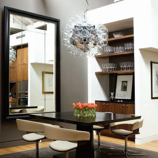 Esempio di una sala da pranzo design con pareti grigie e parquet chiaro