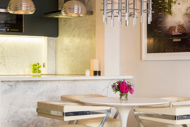 Cette image montre une salle à manger ouverte sur la cuisine design avec un mur blanc et parquet clair.