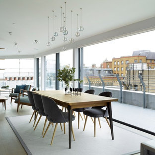 Design ideas for a contemporary open plan dining room in London with grey floors.