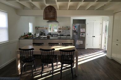 На фото: кухня-столовая среднего размера в стиле кантри с белыми стенами и темным паркетным полом без камина