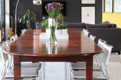 This is an example of a large eclectic open plan dining room with black walls, porcelain flooring and beige floors.