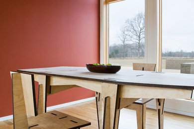 Ejemplo de comedor moderno cerrado con paredes rojas y suelo de madera en tonos medios