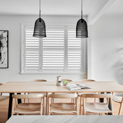 Example of a mid-sized trendy medium tone wood floor and brown floor kitchen/dining room combo design in Wollongong with white walls and no fireplace