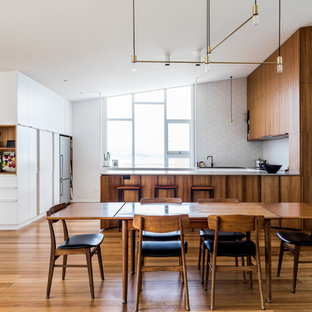 Contemporary kitchen/dining combo in Hobart with white walls, medium hardwood floors and brown floor.