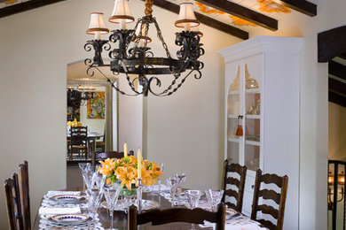 Design ideas for a mediterranean enclosed dining room in Los Angeles with white walls and dark hardwood flooring.