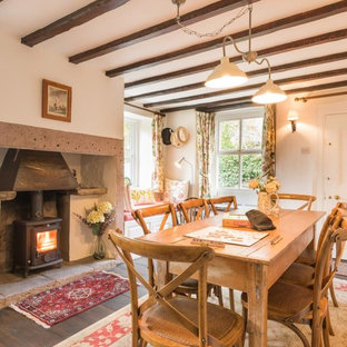 Design ideas for a medium sized farmhouse dining room in Other with white walls, dark hardwood flooring, a wood burning stove and brown floors.