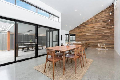 Offenes, Mittelgroßes Modernes Esszimmer ohne Kamin mit weißer Wandfarbe und Betonboden in Sydney