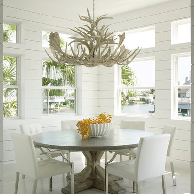 Example of a beach style light wood floor dining room design in Houston with white walls