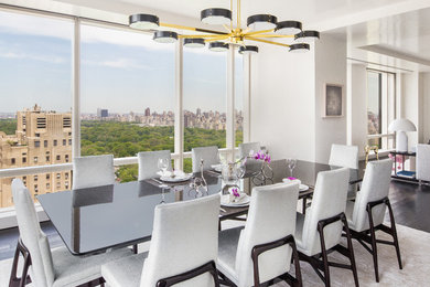 This is an example of a contemporary dining room in New York with white walls, dark hardwood flooring and brown floors.