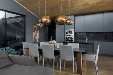 Idee per una grande sala da pranzo aperta verso la cucina minimal con pareti grigie e parquet chiaro