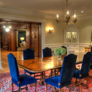 Immagine di una grande sala da pranzo chic chiusa con pareti beige, parquet chiaro, camino classico, cornice del camino in mattoni e pavimento marrone