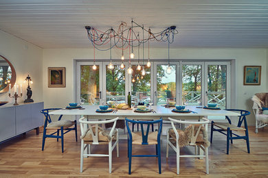 Inspiration pour une salle à manger ouverte sur le salon bohème avec un mur blanc, un sol en bois brun et un sol marron.