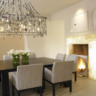 Esempio di una sala da pranzo mediterranea con pareti beige e camino classico