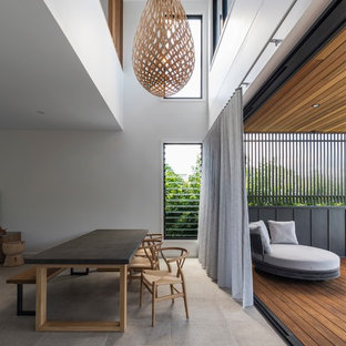 Mid-sized contemporary dining room in Brisbane with white walls, concrete floors and beige floor.