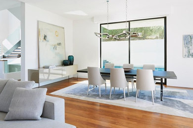 Inspiration for a large contemporary medium tone wood floor great room remodel in Los Angeles with white walls and no fireplace