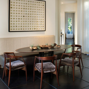 Exemple d'une salle à manger ouverte sur la cuisine moderne de taille moyenne avec un mur beige, un sol en carrelage de céramique et un sol noir.