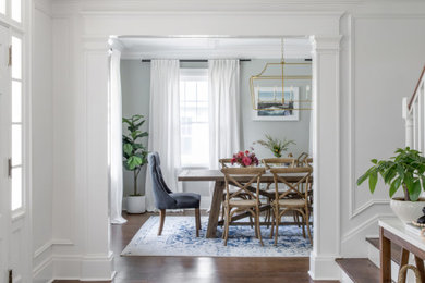 Example of a large transitional medium tone wood floor and coffered ceiling dining room design in New York with gray walls